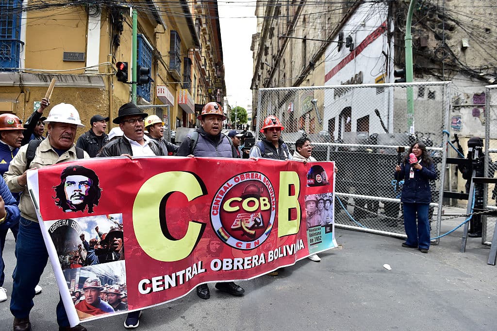 Los mineros portan una pancarta de la Central Obrera Boliviana (COB), el 24 de diciembre de 2025. (Jorge BERNAL / AFP vía Getty Images)