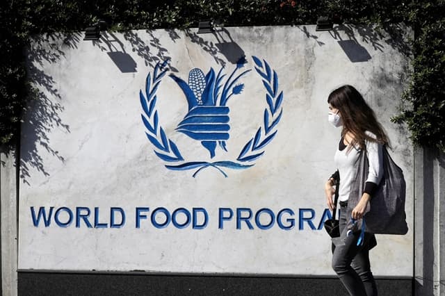 Una mujer pasa junto a un letrero en la entrada del Programa Mundial de Alimentos de la ONU en Roma, el 9 de octubre de 2020. (Foto AP/Gregorio Borgia)