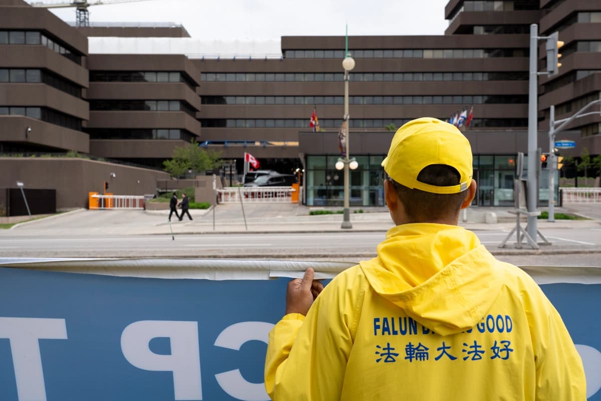 Un practicante de Falun Gong observa el edificio Lester B. Pearson, sede de Asuntos Globales de Canadá, en Ottawa, el 29 de mayo de 2026. (Evan Ning/The Epoch Times)