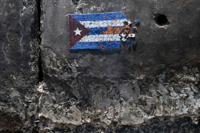 Un mosaico que representa la bandera cubana con forma de rompecabezas se observa ensamblado a partir de piezas de colores en una sección de un muro de fortificación costera a lo largo del malecón en La Habana el 18 de junio de 2026. (Pablo PORCIUNCULA / AFP via Getty Images)