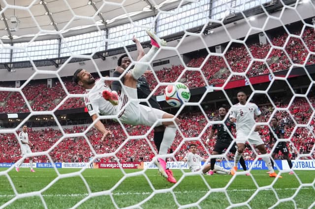 Jonathan David (atrás), de Canadá, anota un gol ante Boualem Khoukhi, de Qatar, durante la primera mitad de un partido de fútbol del Grupo B de la Copa Mundial, en Vancouver, el 18 de junio de 2026. (The Canadian Press/Darryl Dyck).