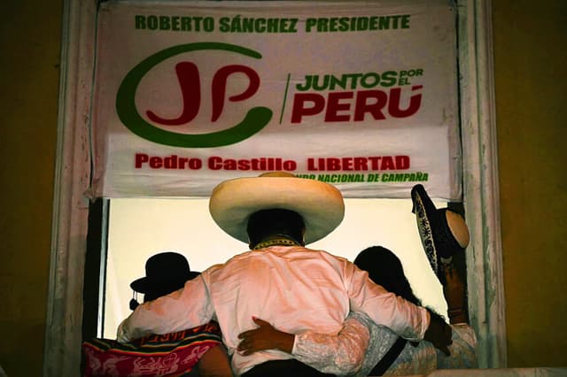 Se ve al candidato presidencial peruano del partido Juntos por el Perú, Roberto Sánchez (C), desde el balcón de su sede de campaña el 19 de junio de 2026. (ERNESTO BENAVIDES / AFP vía Getty Images)