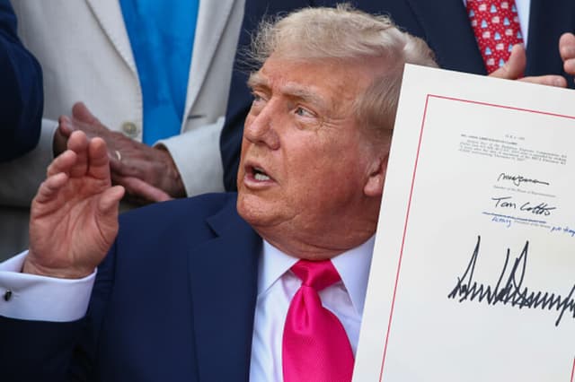 Imagen Ilustrativa: El presidente estadounidense Donald Trump firma la ley One, Big Beautiful Bill junto a legisladores republicanos durante un picnic del Día de la Independencia en la Casa Blanca, el 4 de julio de 2025, en Washington. La norma extiende recortes fiscales y aumenta el gasto en defensa e inmigración, mientras reduce fondos sociales. (Samuel Corum/Getty Images).