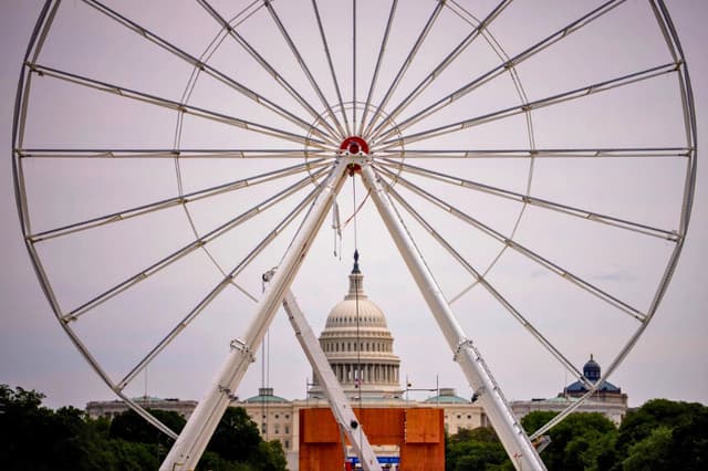 La cúpula del Capitolio de los Estados Unidos se divisa mientras se construye una noria como parte de la "Great American State Fair" de Freedom 250, en el National Mall de Washington, el 19 de junio de 2026. Esta celebración, de 16 días de duración y a escala de una Exposición Universal, conmemora el 250.º aniversario de Estados Unidos y se celebrará del 25 de junio al 10 de julio, en la que se darán a conocer todos los estados y territorios de EE. UU. (Andrew Harnik/Getty Images).