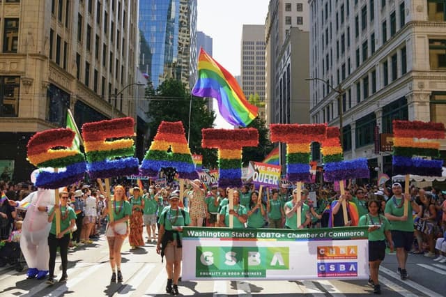 Los participantes en el desfile enarbolan una bandera arcoíris gigante durante el desfile anual del Orgullo de Seattle, celebrado en Seattle, Washington, el 25 de junio de 2023. (Lindsey Wasson/AP).