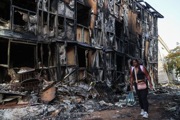 Una persona camina frente a unos edificios calcinados en Catia La Mar tras los terremotos de magnitud 7.2 y 7.5 que sacudieron Venezuela y otras regiones del Caribe el 26 de junio de 2026 en La Guaira, Venezuela. (Edilzon Gamez/Getty Images)
