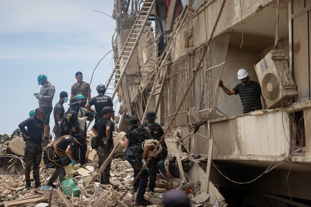Un grupo de rescatistas fue captado este 28 de junio al realizar labores de búsqueda de personas desaparecidas en una zona afectada por los terremotos del pasado miércoles, en Catia La Mar, La Guaira, Venezuela. (EFE/Ronald Peña)
