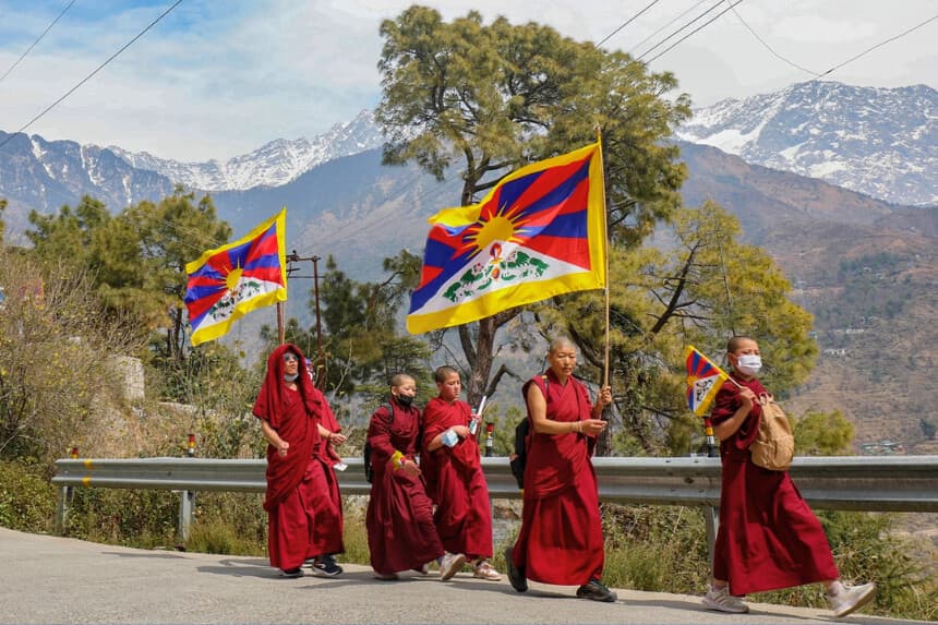 Monjes tibetanos que viven exiliados en la India portan banderas tibetanas durante una marcha por la paz en el 65º Día Nacional del Levantamiento Tibetano contra la ocupación china del Tíbet, en el suburbio de McLeod Ganj, cerca de Dharamsala, India, el 10 de marzo de 2024. (Sanjay Baid/AFP vía Getty Images).