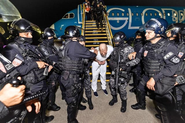 Guardias escoltan a un recluso recién ingresado, presuntamente vinculado a organizaciones criminales, en el centro de detención CECOT en Tecoluca, El Salvador, el 16 de marzo de 2025. (Gobierno salvadoreño vía Getty Images).