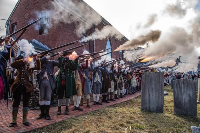Recreadores de la Guerra de Independencia disparan salvas en la Capilla de San Agustín al inicio de las ceremonias del Día de la Evacuación en Boston, el 17 de marzo de 2026. (Joseph Prezioso/AFP vía Getty Images)