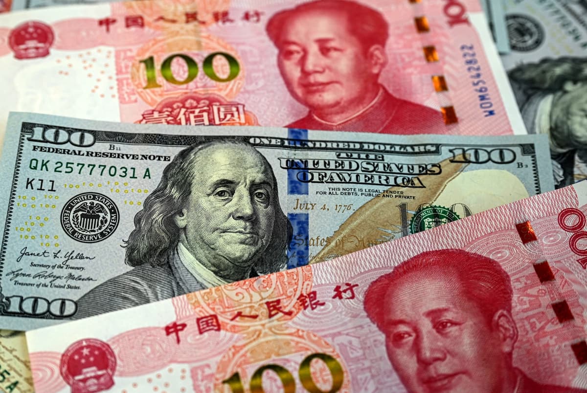 Esta foto ilustrativa muestra billetes chinos de 100 yuanes (rojos) y billetes de 100 dólares estadounidenses en Beijing, el 8 de abril de 2025. (Jade Gao /AFP vía Getty Images).