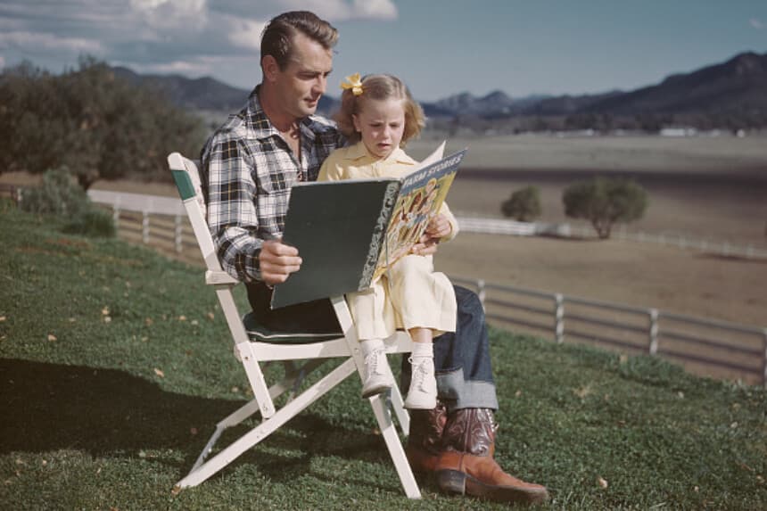 El actor estadounidense Alan Ladd (1913-1964) leyendo "Cuentos de la granja" a su hija Alana, EE. UU., alrededor de 1948. (Archive Photos/Getty Images).