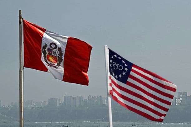 Ilustración de The Epoch Times. Una bandera nacional peruana ondea en la playa de Chorrillos, en Lima, el 11 de abril de 2026. (Luis ROBAYO / AFP vía Getty Images); Insertada: Bandera conmemorativa del semicincentenario de los Estados Unidos el 4 de julio de 2026 en Columbus, Ohio. (Dylan Buell/Getty Images)