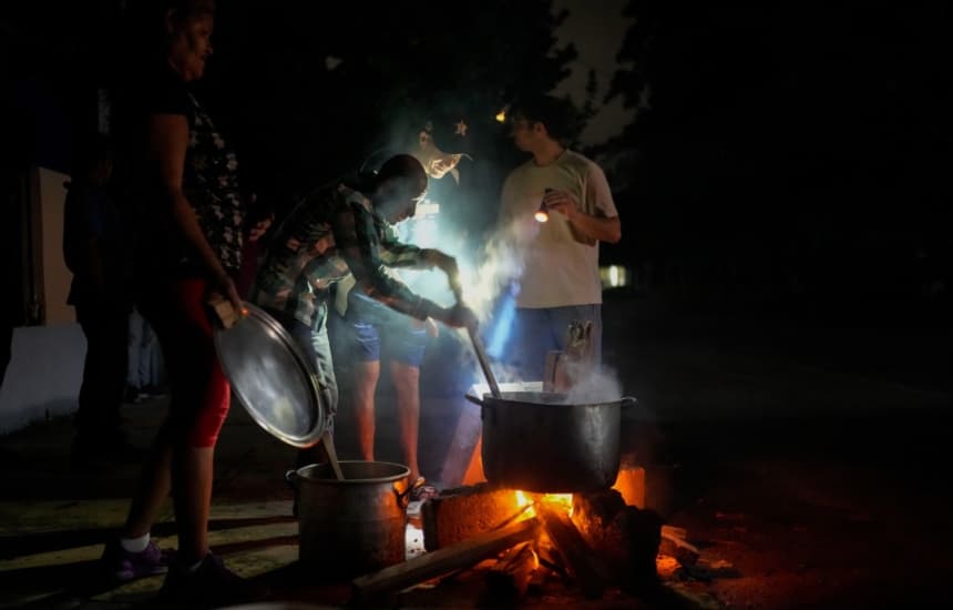 Residentes preparan una sopa sobre una hoguera durante un apagón provocado por el fallo de una importante central eléctrica en La Habana, Cuba, el 19 de octubre de 2024. (Ramon Espinosa/AP).
