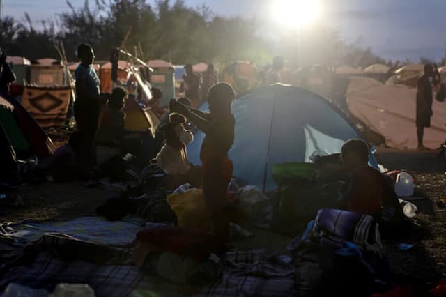 Un niño juega con un perro de peluche en un campamento de migrantes en Del Rio, Texas, el 21 de septiembre de 2021. Unas 14,000 personas, en su mayoría haitianas, vivían en refugios improvisados cerca del puente internacional, mientras las autoridades estadounidenses deportaban migrantes a Haití y otros regresaban a México. (John Moore/Getty Images).