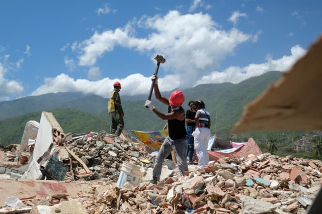 Voluntarios trabajan en la remoción de escombros de los edificios Mision Vivienda OPPE luego del doble terremoto de magnitud 7.2 y 7.5 ocurrido el pasado 24 de Junio, este martes en La Guaira, Venezuela. (EFE/ Xaume Olleros)