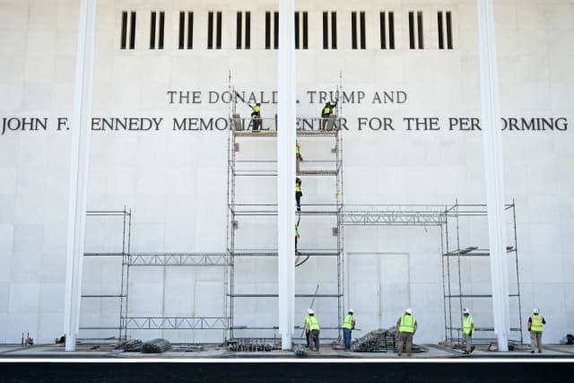 Trabajadores se encuentran en andamios cerca del letrero del Centro Conmemorativo Donald J. Trump y John F. Kennedy para las Artes Escénicas, mientras continúan los esfuerzos para eliminar el nombre del presidente Donald Trump del recinto en Washington el 12 de junio de 2026. (Alex Wroblewski/AFP vía Getty Images)
