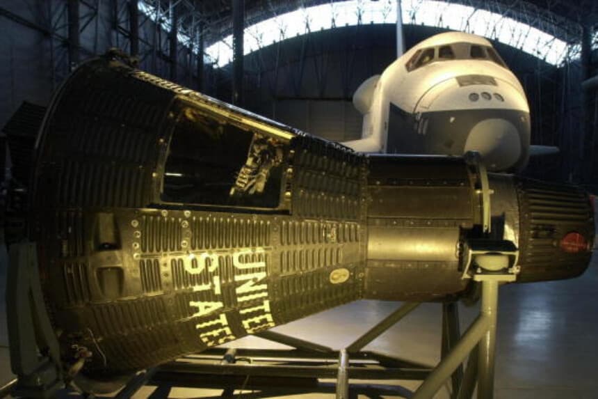 El transbordador espacial Enterprise (al fondo) y la cápsula Mercury 15B "Freedom 7" (al frente) se exhiben en el Museo Nacional del Aire y el Espacio, Centro Steven F. Udvar-Hazy, en Chantilly, Virginia, el 11 de diciembre de 2003. (Joyce Naltchayan/AFP vía Getty Images).