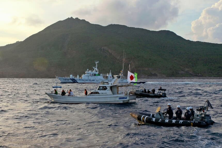 Un buque guardacostas japonés y otras embarcaciones (atrás y a la derecha) navegan junto a un barco pesquero de activistas japoneses (en el centro) cerca de un grupo de islas en disputa, llamadas Diaoyu por China y Senkaku por Japón, el 18 de agosto de 2013. (Foto de Emily Wang/AP).