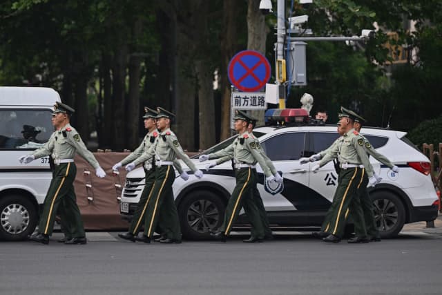 Agentes de la policía china patrullan en Beijing el 14 de mayo de 2026. (Pedro Pardo/AFP vía Getty Images).