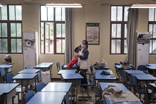 Una estudiante de último año transporta libros mientras se traslada a una nueva aula en Wuhan, provincia de Hubei, China, el 6 de mayo de 2020. (Getty Images).