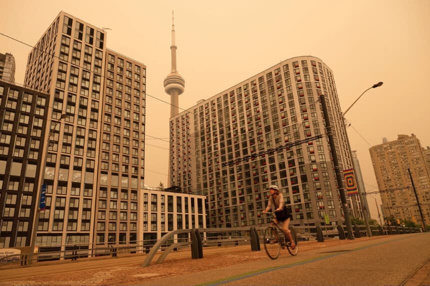 Una mujer recorre el paseo marítimo en Toronto mientras el humo de los incendios forestales llena la ciudad, el 15 de julio de 2026. (The Canadian Press/Laura Proctor).