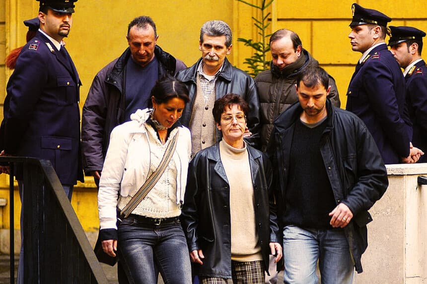 Agentes de policía italianos escoltan a Rita Algranati (en el centro, abajo) y a Maurizio Falessi (en el centro, arriba), miembros del grupo de extrema izquierda Brigadas Rojas, el 14 de enero de 2003. Algranati está casada con Alessio Casimirri, buscado por la policía en relación con el asesinato de Moro. La policía cree que se encuentra escondido en Nicaragua. (ANDREAS SOLARO/AFP vía Getty Images)