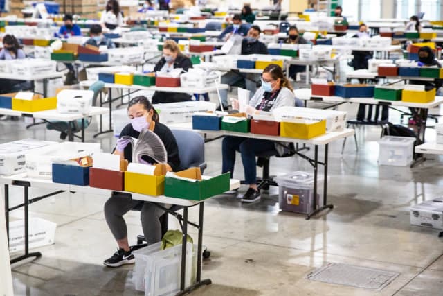 Personas procesan boletas electorales en un centro del Registro Civil de Los Ángeles, ubicado en el recinto ferial de Los Ángeles en Pomona, California, el 31 de agosto de 2021. (John Fredricks/The Epoch Times)