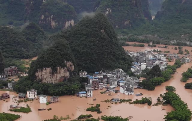 Las calles y los edificios están sumergidos bajo las aguas de la inundación en Yangshuo, en la región de Guangxi, al sur de China, el 7 de junio de 2020. (STR/AFP vía Getty Images)