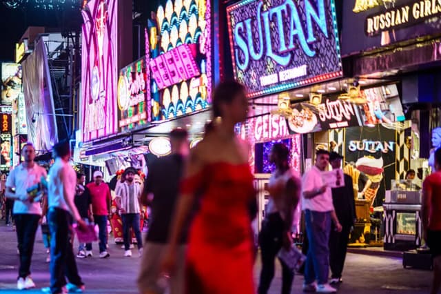 El 3 de julio de 2026, la gente camina frente a bares y clubes en Walking Street, en Pattaya, Tailandia. Cientos de chicas, algunas aparentemente muy jóvenes, con poca ropa y tacones de aguja, forman una sórdida guardia de honor bajo las luces de Soi 6, una calle en uno de los barrios rojos de Pattaya. (Anthony Wallace/AFP vía Getty Images).