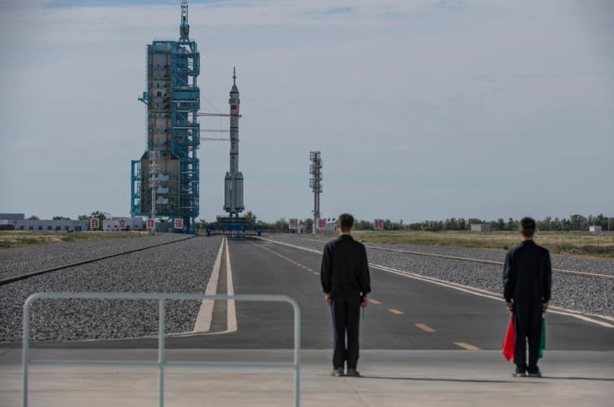 Unos trabajadores se encuentran cerca de la nave espacial tripulada Shenzhou-12, de la Agencia Espacial Tripulada de China, a bordo del cohete Long March-2F antes de su lanzamiento con tres astronautas chinos a bordo en el Centro de Lanzamiento de Satélites de Jiuquan, en la provincia de Gansu, China, el 17 de junio de 2021. (Kevin Frayer/Getty Images)