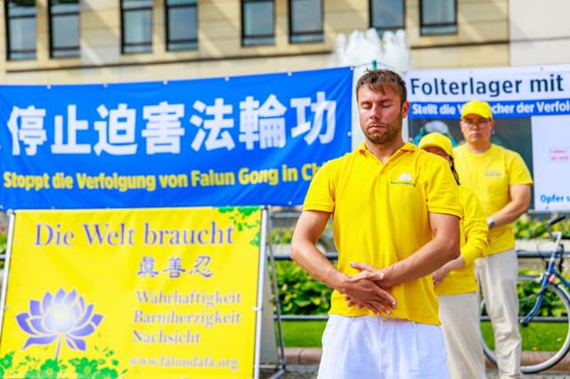 Los practicantes de Falun Gong se reúnen en la Puerta de Brandeburgo de Berlín el 18 de julio de 2026 para dar a conocer la persecución que el Partido Comunista Chino lleva a cabo contra esta práctica espiritual, que comenzó en julio de 1999. (Cortesía de Minghui.org).