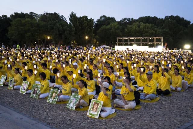 Practicantes de Falun Dafa durante una vigilia con velas en el Monumento a Lincoln en Washington el 23 de julio de 2026. (Madalina Kilroy/The Epoch Times)