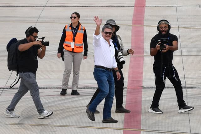 El expresidente de Honduras, Juan Orlando Hernández, saluda desde la pista tras llegar en un vuelo privado al Aeropuerto Internacional de Palmerola, en Comayagua, Honduras, el 26 de julio de 2026. (Orlando Sierra/AFP vía Getty Images)