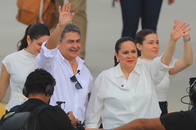 El expresidente hondureño Juan Orlando Hernández (2-i) fue captado, este 26 de julio, al saludar a su llegada al Aeropuerto de Palmerola, en Comayagua, Honduras. (EFE/Gustavo Amador)
