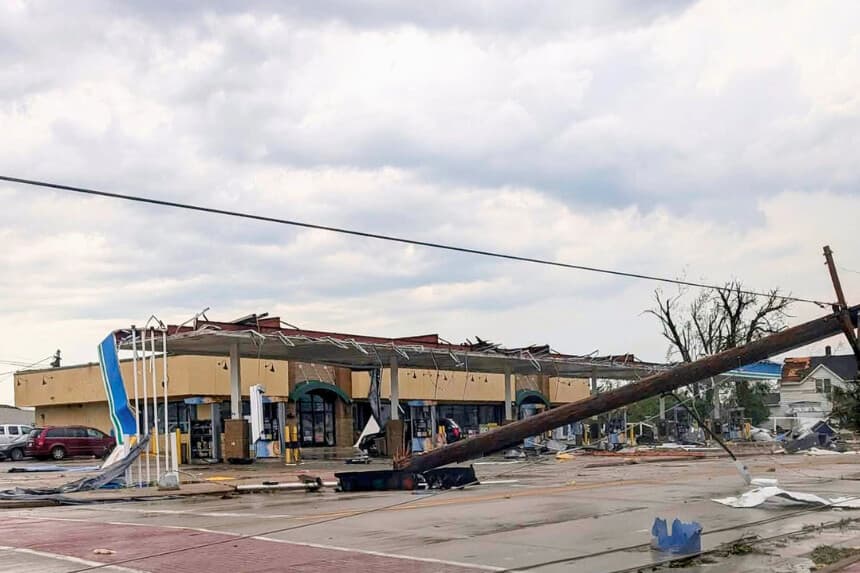 En esta fotografía proporcionada por Douglas Tom Williams, un poste telefónico cuelga sobre una carretera llena de escombros a causa de una fuerte tormenta en Menasha, Wisconsin, el 27 de julio de 2026. (Douglas Tom Williams vía AP).