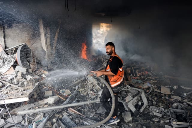Un bombero intenta extinguir un incendio en un edificio destruido tras un ataque israelí en la calle Al-Jalaa, en la ciudad de Gaza, el 24 de julio de 2026. (Omar Al-Qattaa/AFP vía Getty Images)