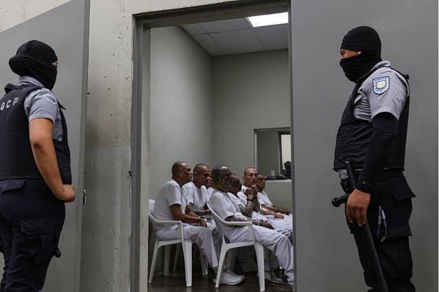 Funcionarios penitenciarios montan guardia durante una audiencia masiva contra delincuentes y miembros de pandillas en el CECOT el 23 de abril de 2026 en Tecoluca, El Salvador. (Alex Peña/Getty Images)