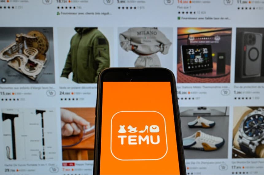 Logotipo de la empresa china de comercio electrónico Temu mostrado en un teléfono móvil sostenido frente a una pantalla con la página web de la empresa, en Bruselas, el 4 de noviembre de 2024. (Nicolas Tucat/AFP vía Getty Images).
