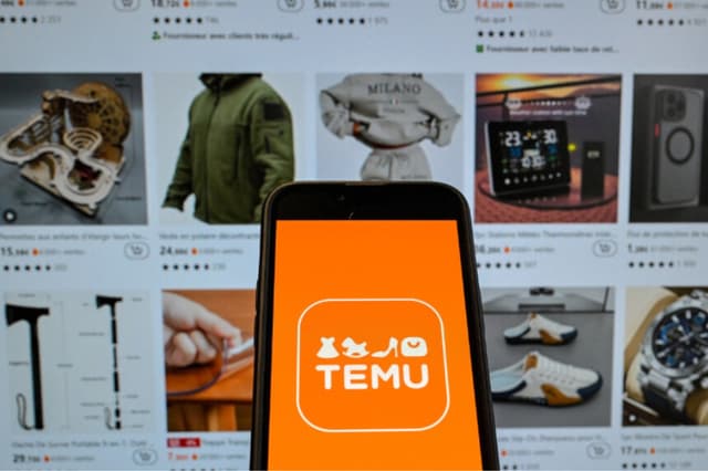 Logotipo de la empresa china de comercio electrónico Temu mostrado en un teléfono móvil sostenido frente a una pantalla con la página web de la empresa, en Bruselas, el 4 de noviembre de 2024. (Nicolas Tucat/AFP vía Getty Images).