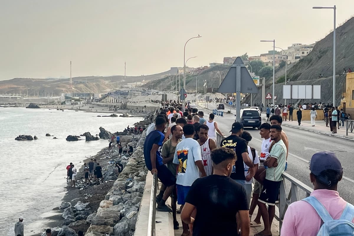 Multitudes de jóvenes migrantes marroquíes se concentran a lo largo de la carretera costera cerca de la Avenida Martínez Catena, en el territorio español de Ceuta, el 31 de julio de 2026, tras cruzar a nado desde Marruecos. (Etienne Fauchaire/The Epoch Times)
