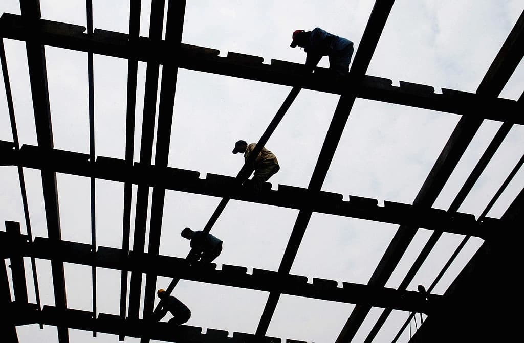 Trabajadores construyen la quilla de un barco en el astillero estatal de Guangzhou, en la provincia de Guangdong, China, el 23 de marzo de 2005. (China Photos/Getty Images)