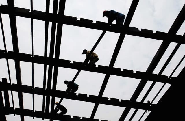 Trabajadores construyen la quilla de un barco en el astillero estatal de Guangzhou, en la provincia de Guangdong, China, el 23 de marzo de 2005. (China Photos/Getty Images)