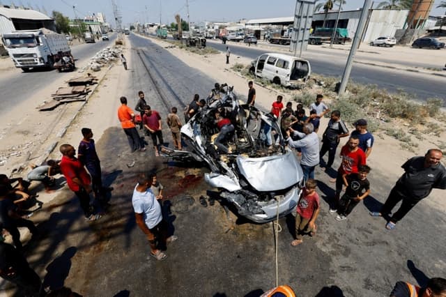 Palestinos inspeccionan el lugar donde, según los servicios médicos, un ataque israelí alcanzó un vehículo en Deir al-Balah, en la Franja de Gaza central, el 2 de agosto de 2026. (Mahmoud Issa/Reuters)