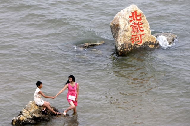 Caracteres chinos en rojo escritos sobre una roca forman la palabra "Beidaihe" en la ciudad costera de Beidaihe, China, el 8 de agosto de 2008. (AP/Silvia Izquierdo).