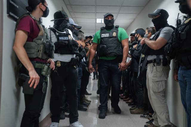 Agentes federales enmascarados esperan fuera de una sala de inmigración en Nueva York el 8 de julio de 2025. (Olga Fedorova/AP).