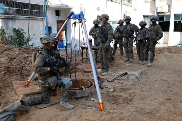 Soldados israelíes inspeccionan la entrada a un túnel terrorista de Hamás justo frente a un complejo de la Agencia de las Naciones Unidas para Refugiados Palestinos en el Cercano Oriente (UNRWA) en la ciudad de Gaza el 8 de febrero de 2024. (Jack Guez/AFP vía Getty Images).