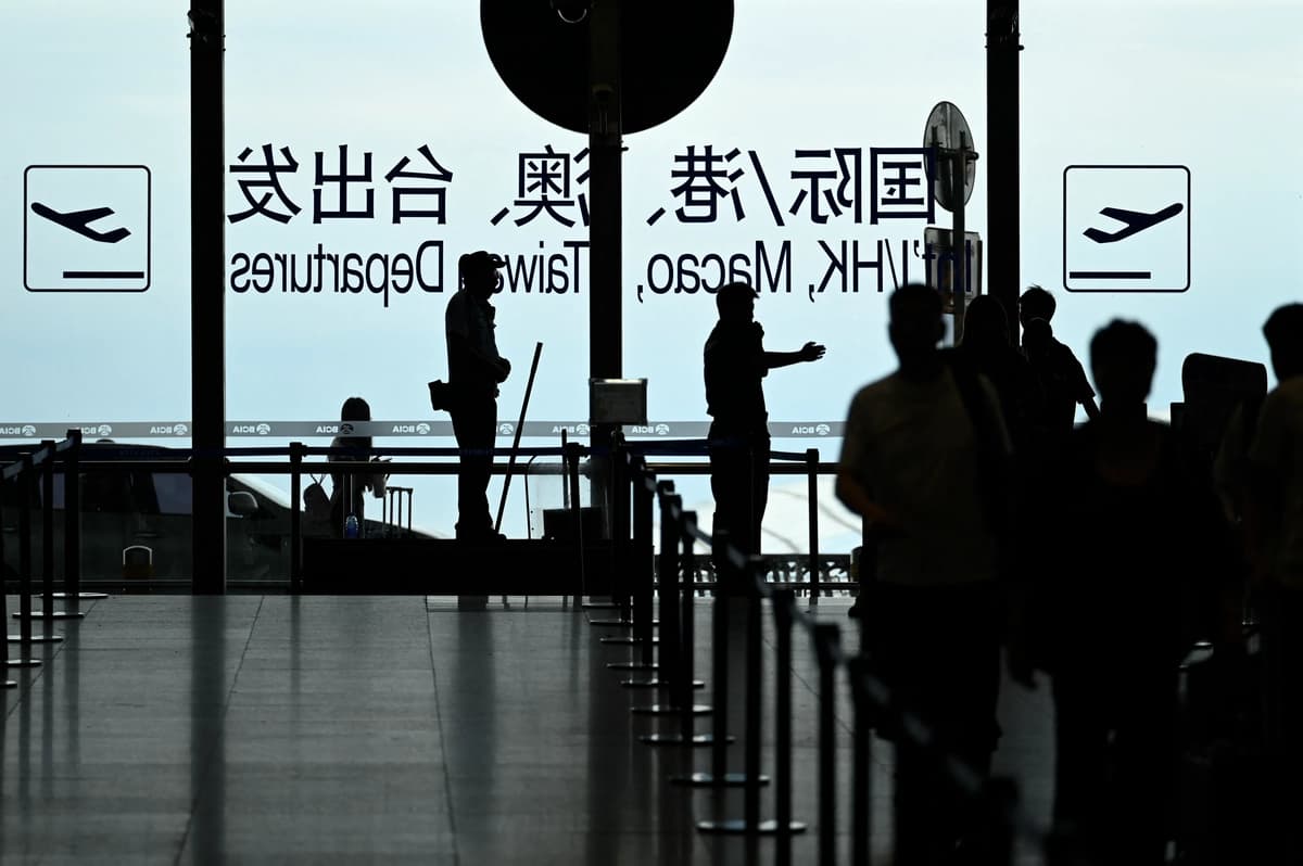 Un guardia de seguridad guía a los pasajeros en el aeropuerto internacional de Beijing el 6 de julio de 2025. (Wang Zhao/AFP vía Getty Images)