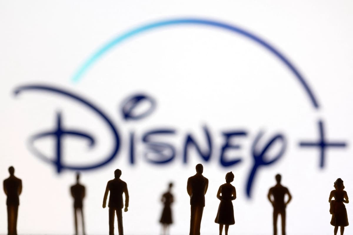 En esta ilustración, tomada el 20 de enero de 2022, se ven figuras de juguete de personas frente al logotipo de Disney+. (Dado Ruvic/Reuters)