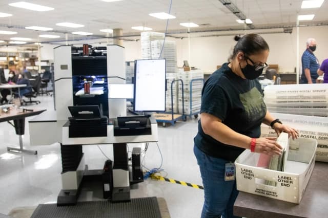 Un miembro del personal del Departamento Electoral del condado de Maricopa cuenta boletas electorales antes de las elecciones del martes en Phoenix, Arizona, el 31 de octubre de 2020. (Courtney Pedroza/Getty Images)